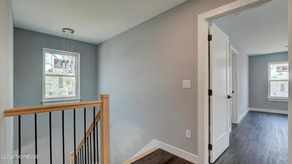 a view of a hallway with wooden floor and a window