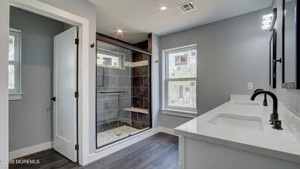 a bathroom with a shower sink and mirror