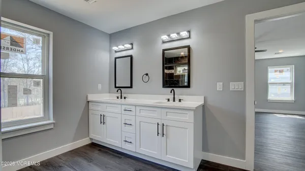 a spacious bathroom with a double vanity sink a mirror and a window