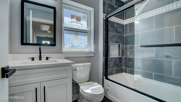 a bathroom with a sink toilet vanity and shower
