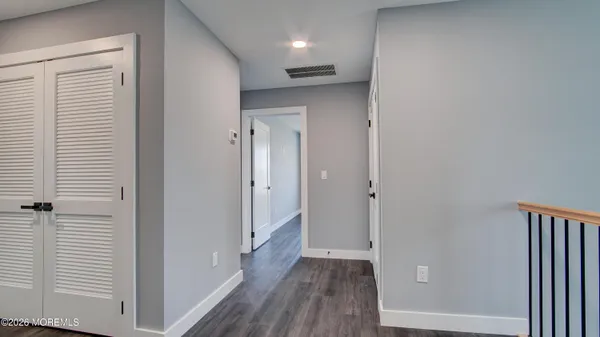a view of a hallway with wooden floor