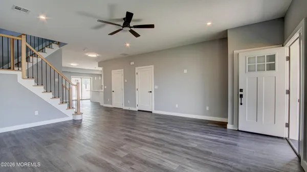 a view of empty room with wooden floor and ceiling fan