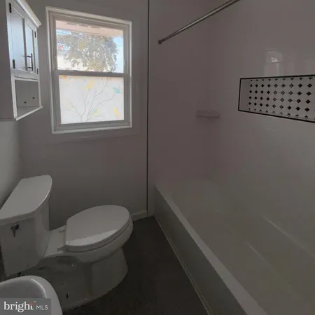 a white toilet sitting next to a window