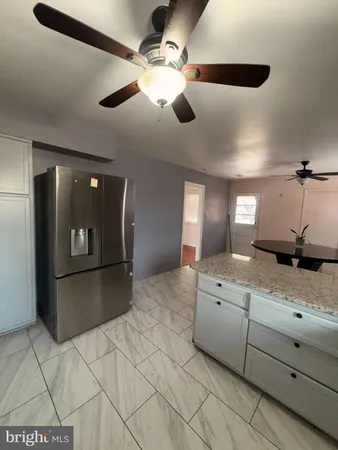 a spacious bathroom with a granite countertop sink and a mirror