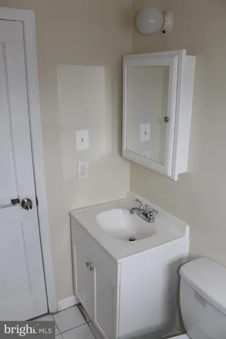 a bathroom with a sink and mirror with toilet