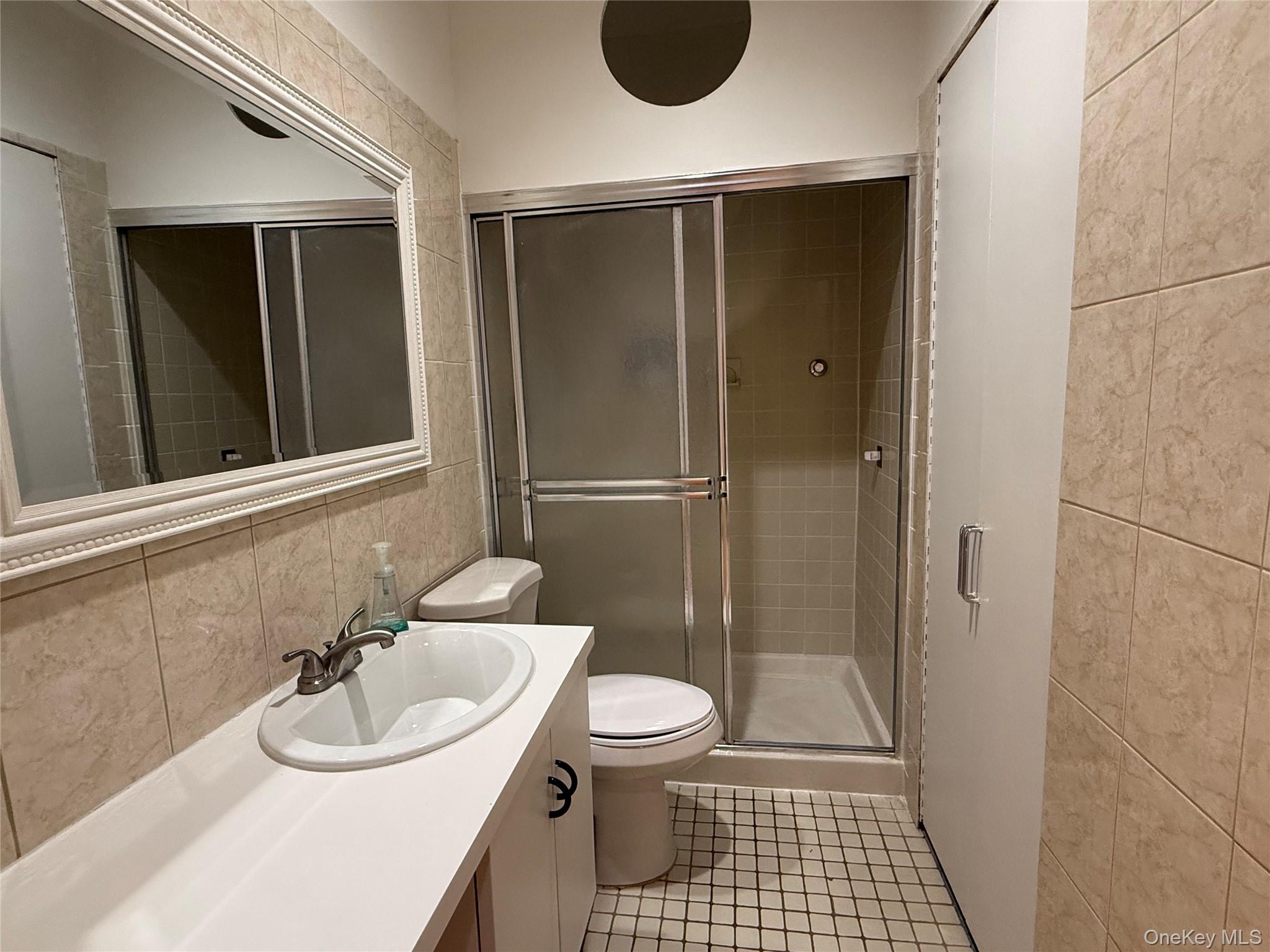 130 South Middle Neck Road, Unit 2 Great Neck, NY 11021 - Photo 14 of 22 a bathroom with a sink a toilet and shower