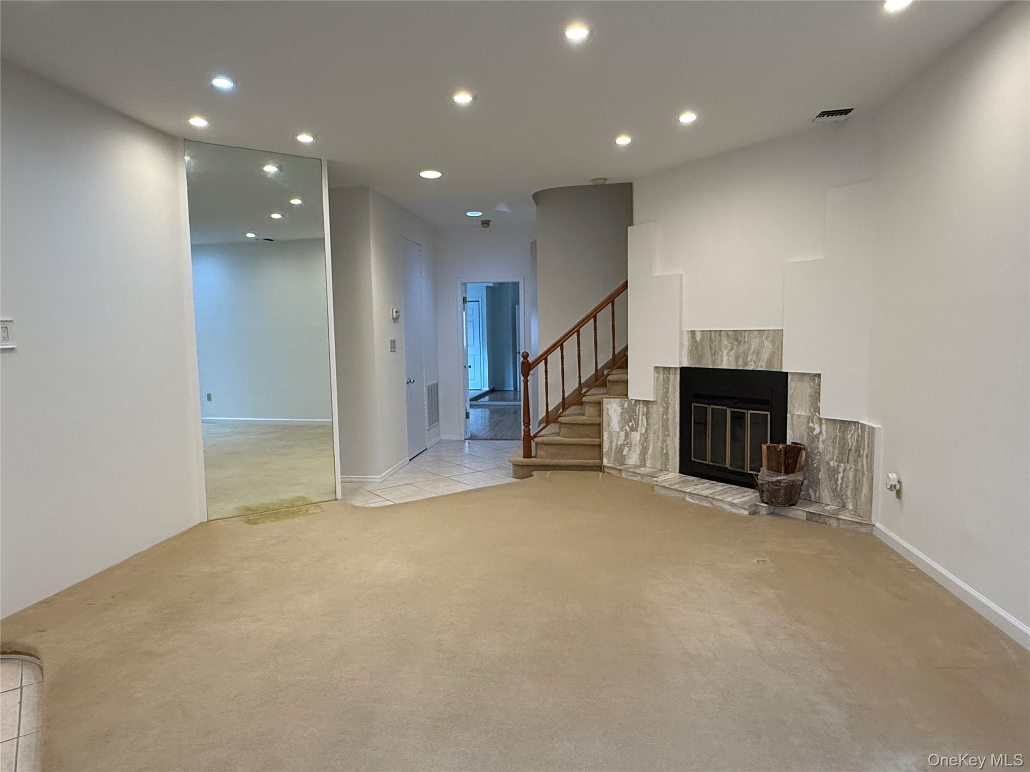 130 South Middle Neck Road, Unit 2 Great Neck, NY 11021 - Photo 6 of 22 an empty room with fireplace and windows