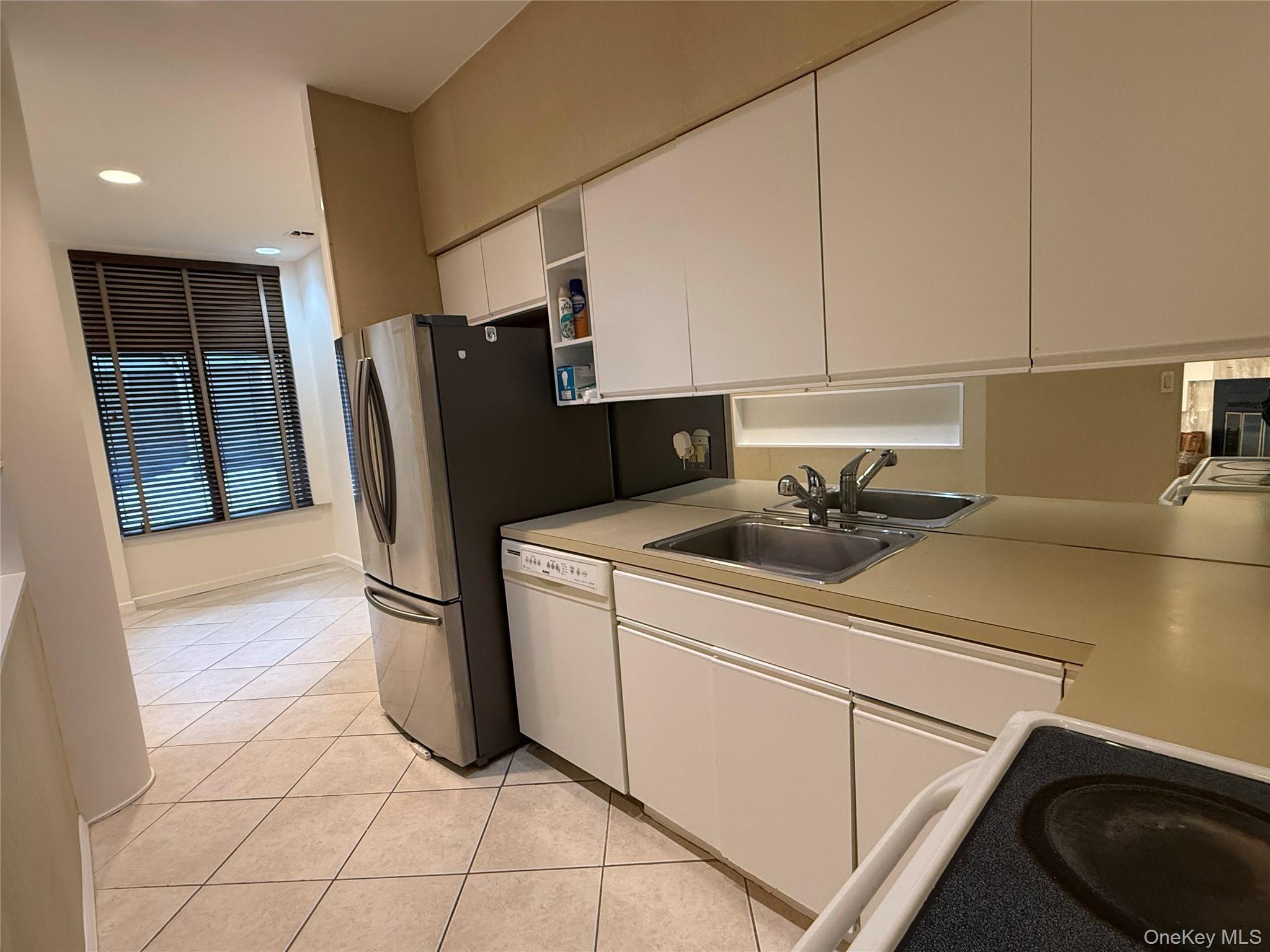 130 South Middle Neck Road, Unit 2 Great Neck, NY 11021 - Photo 9 of 22 a kitchen with a sink a refrigerator and cabinets