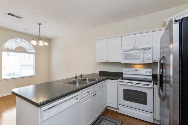 a kitchen with cabinets stainless steel appliances a sink and a stove