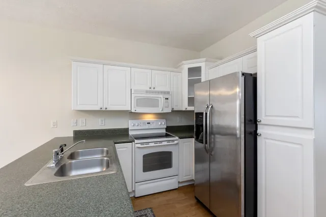 a kitchen with a refrigerator sink and cabinets