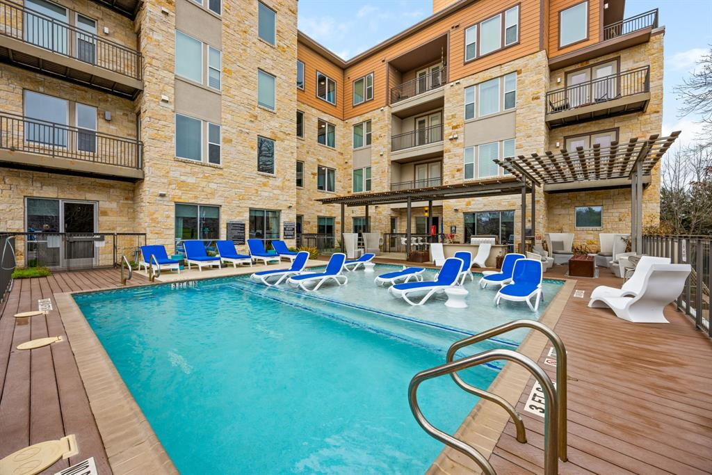 1900 Barton Springs Road, Unit 3013 Austin, TX 78704 - Photo 23 of 27 A refreshing pool awaits, surrounded by lounging areas and an inviting pergola, perfect for relaxation.