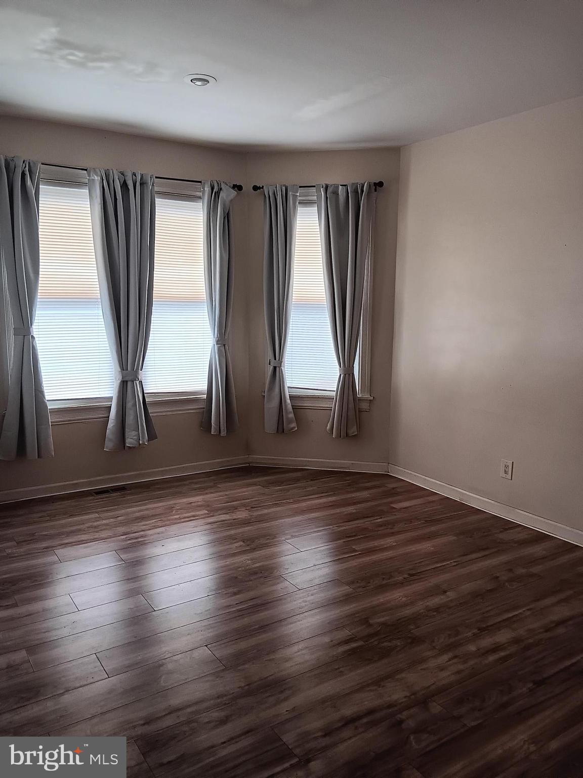 712 Central Avenue, Unit B Glendora, NJ 08029 - Photo 7 of 11 an empty room with wooden floor and windows