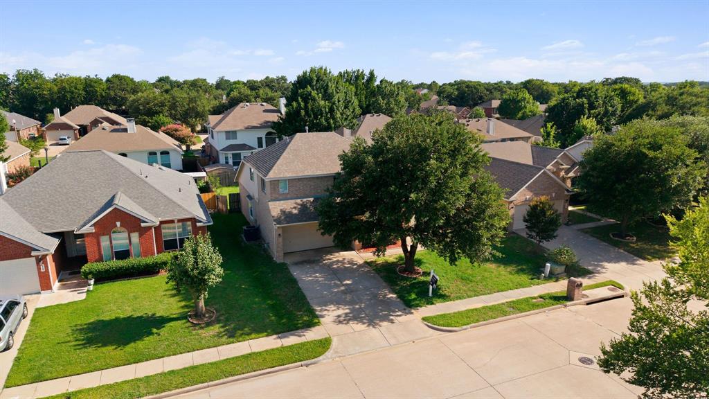 2700 Hereford Road Denton, TX 76210 - Photo 34 of 36 Two-story residence featuring a two-car garage, mature trees, and a concrete driveway