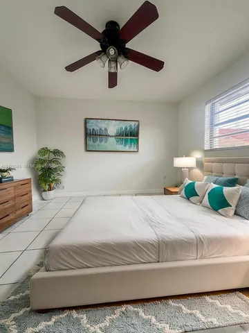 a bedroom with a bed and ceiling fan