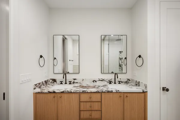 a bathroom with a granite countertop sink mirror bathtub and toilet