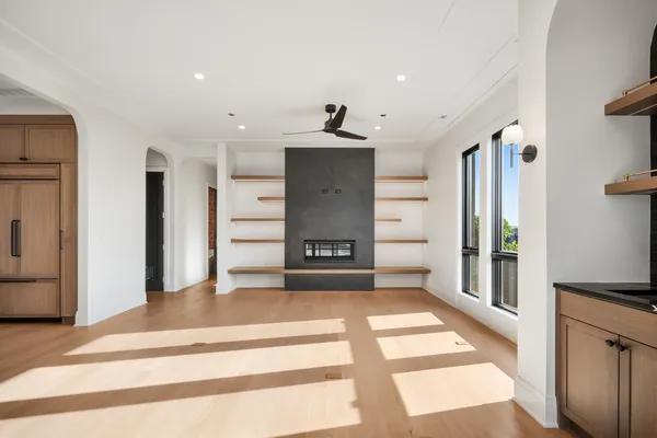 a view of an empty room with a window and fireplace