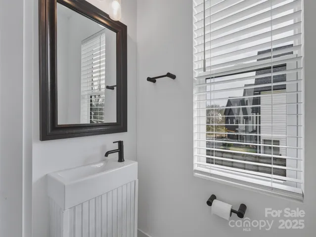 a bathroom with a sink a mirror and a window