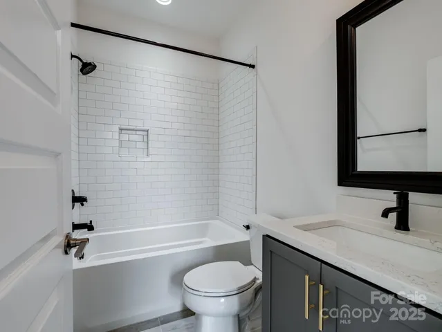 a bathroom with a granite countertop toilet a sink and a bathtub