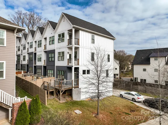 a view of a white building among the street and chairs