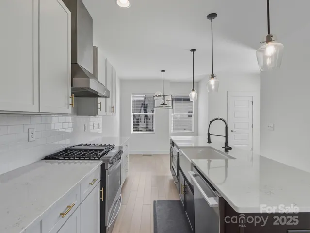 a kitchen with stainless steel appliances granite countertop a sink a stove and a granite counter tops