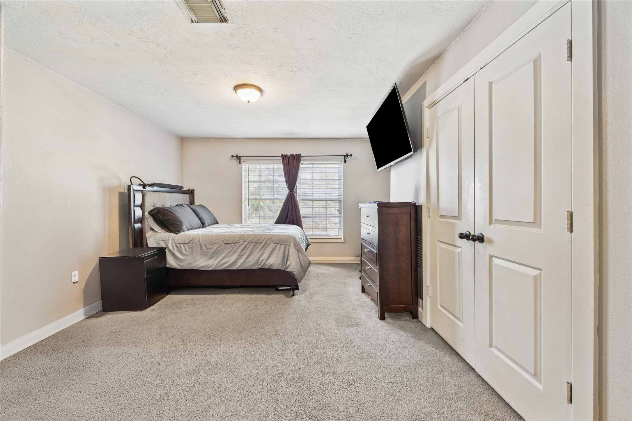 31306 Summit Grove Lane Spring, TX 77386 - Photo 18 of 45 a bedroom with a bed flat screen tv and a couch