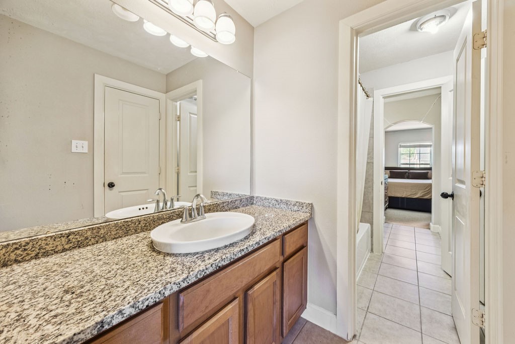 31306 Summit Grove Lane Spring, TX 77386 - Photo 21 of 45 a bathroom with a granite countertop sink and a mirror