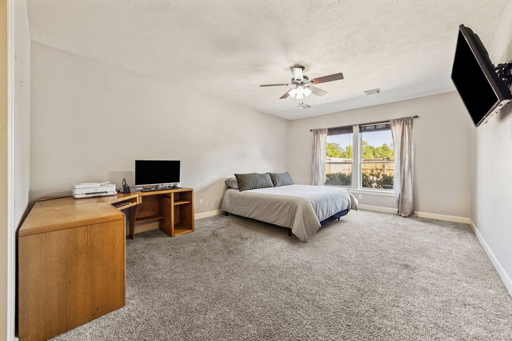 31306 Summit Grove Lane Spring, TX 77386 - Photo 10 of 45 a spacious bedroom with a bed and a flat screen tv