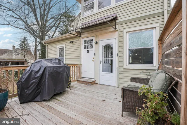a view of a white house with large windows and a small yard