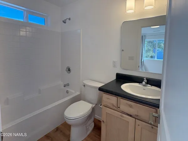 a bathroom with a sink toilet vanity tub and shower