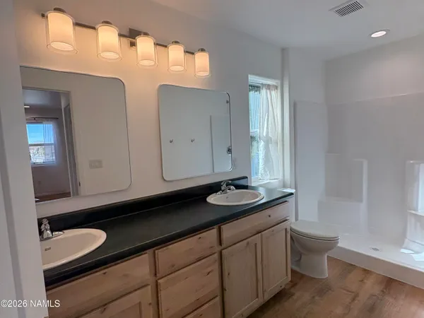 a bathroom with a granite countertop sink a toilet and a mirror