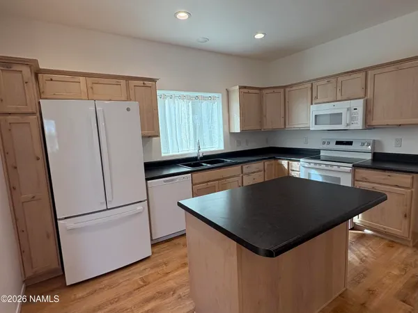 a kitchen with stainless steel appliances granite countertop a refrigerator a sink dishwasher a stove and a refrigerator