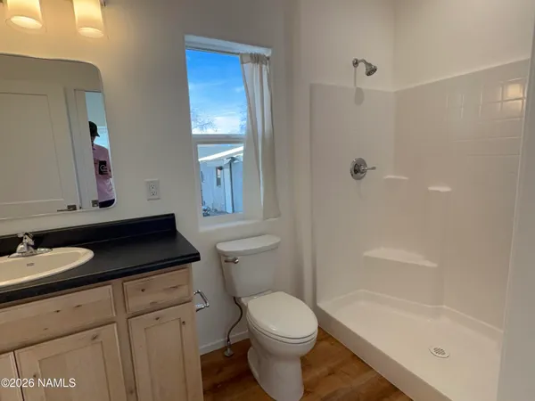 a bathroom with a granite countertop sink a toilet and shower