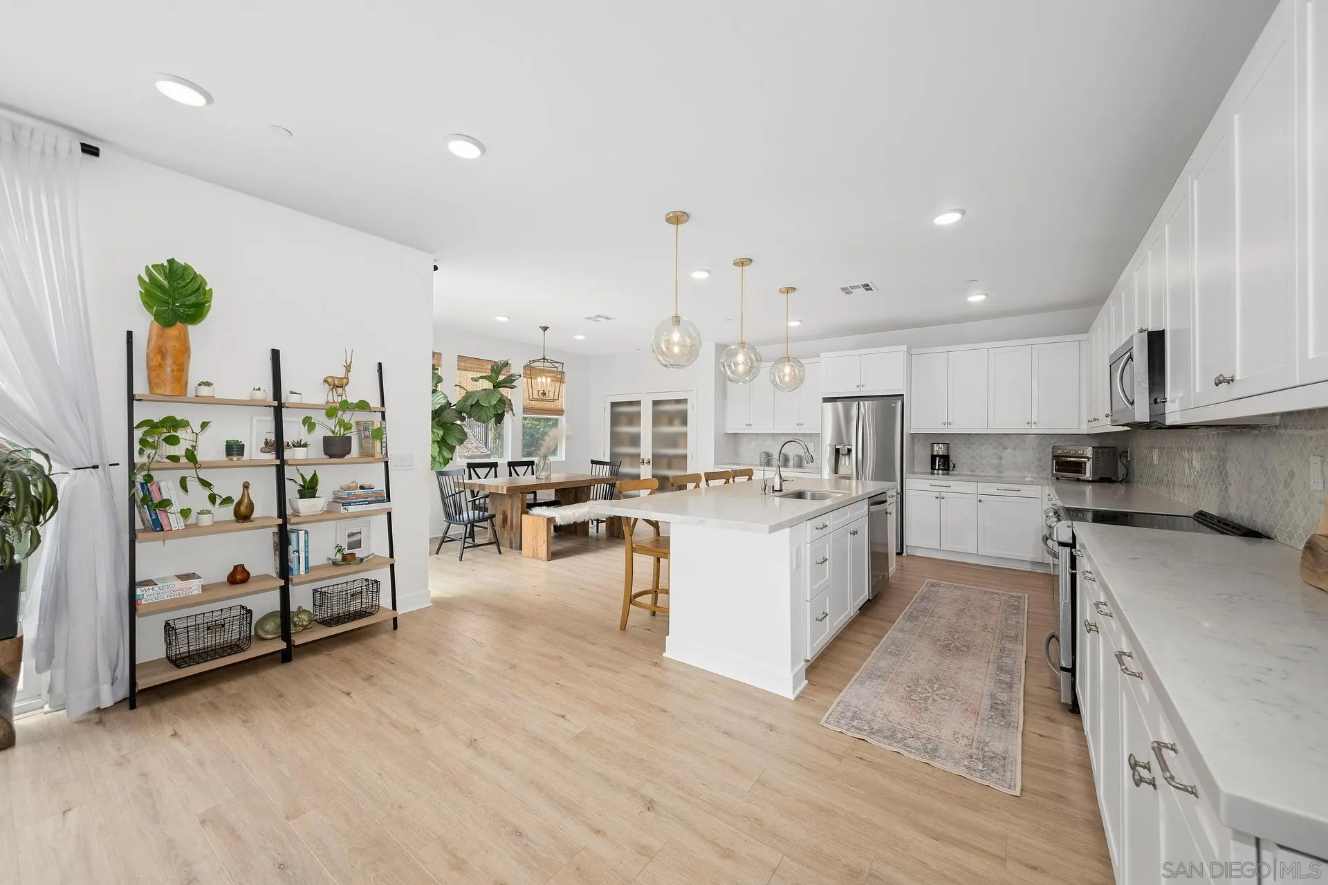 8850 Weston Road Santee, CA 92071 - Photo 4 of 44 a kitchen with white cabinets and wooden floor