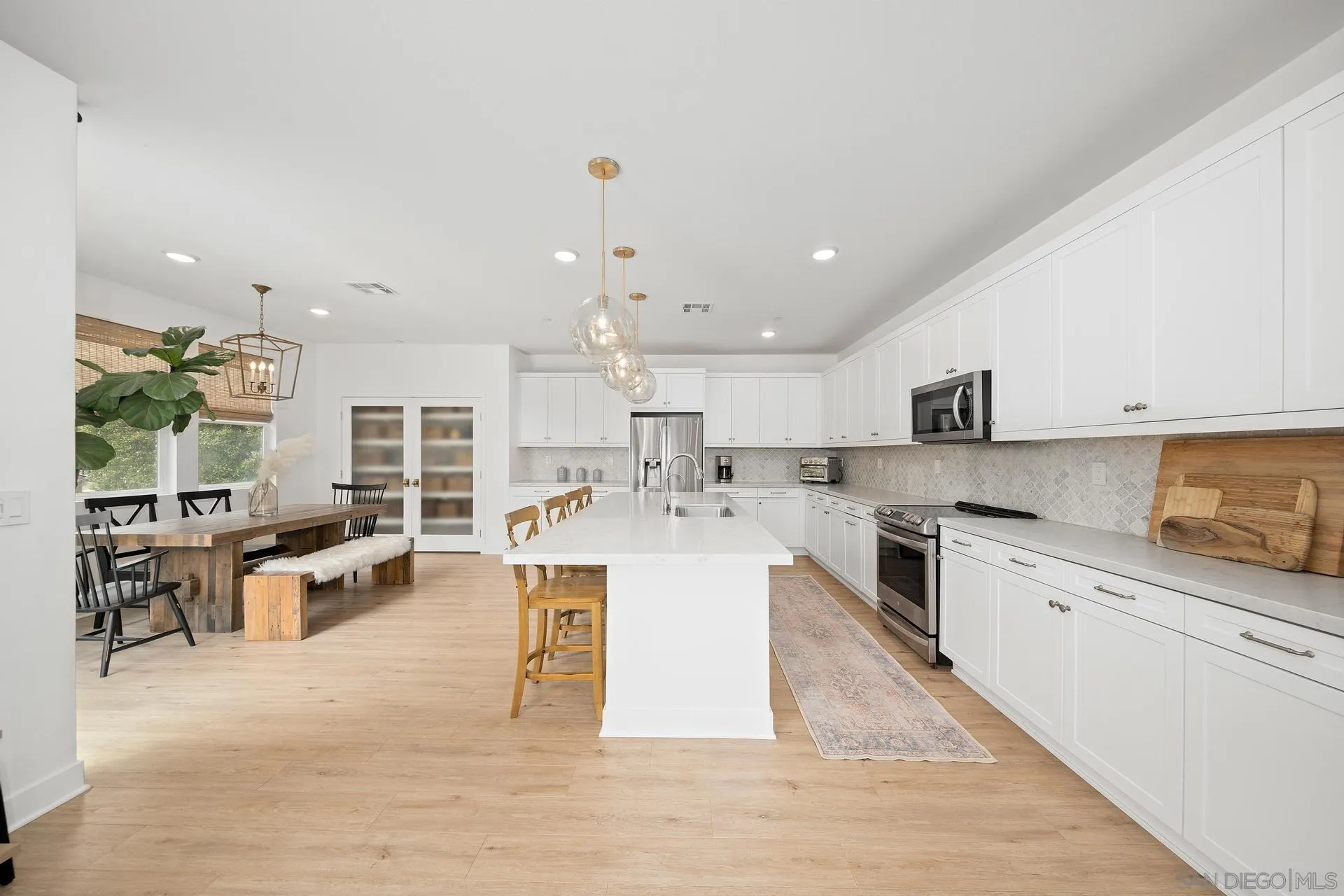 8850 Weston Road Santee, CA 92071 - Photo 6 of 44 a large white kitchen with lots of counter space wooden floor and appliances