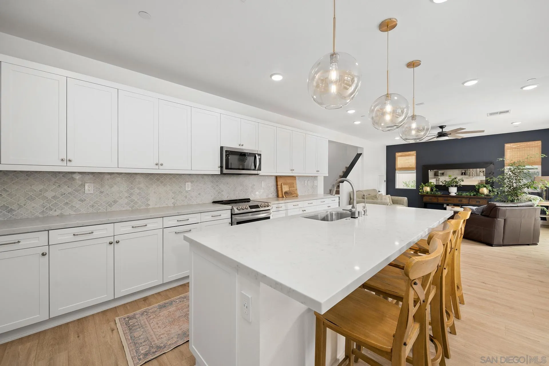 8850 Weston Road Santee, CA 92071 - Photo 7 of 44 a kitchen with a stove a sink dishwasher a kitchen island with chairs and cabinets