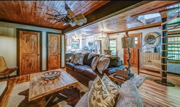 a living room with furniture a wooden floor and next to a window