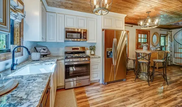 a kitchen with stainless steel appliances granite countertop a refrigerator stove and sink