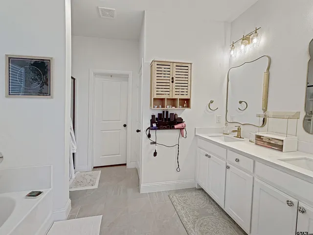 a spacious bathroom with a double vanity sink mirror and
