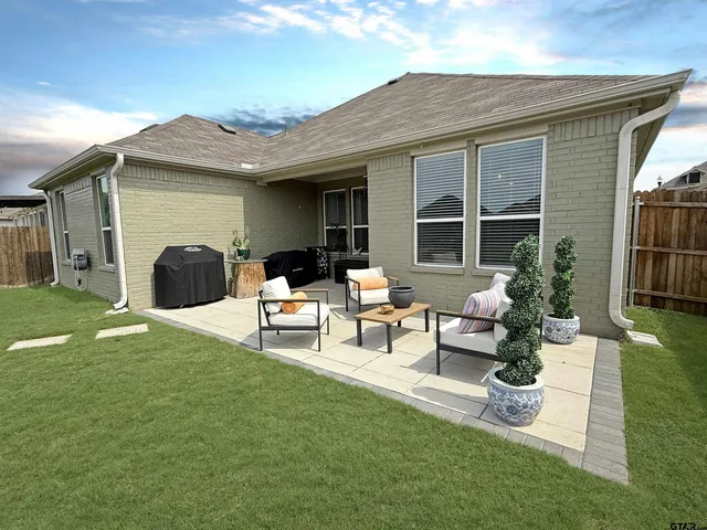 a view of a house with backyard and a garden