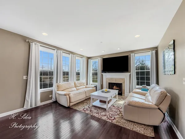 a living room with furniture a flat screen tv and a fireplace