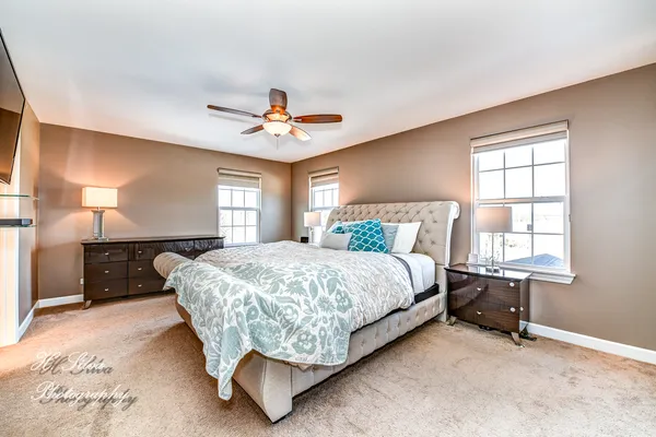 a bed sitting in a spacious bedroom next to a window