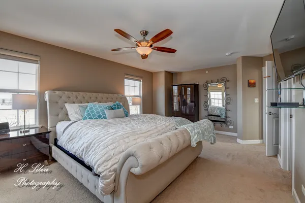 a bedroom with a large bed and a chandelier