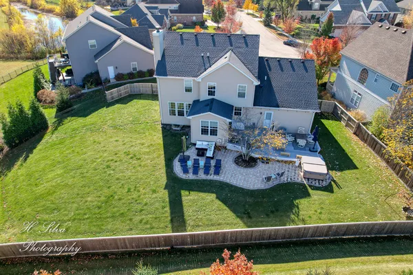 an aerial view of a house with a garden and lake view