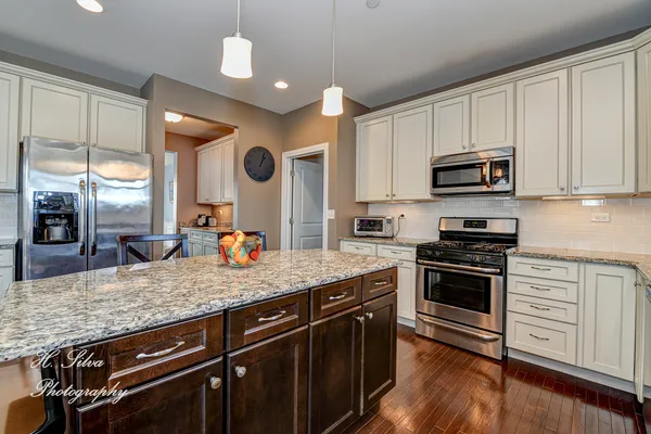 a kitchen with stainless steel appliances granite countertop a stove a sink and a microwave