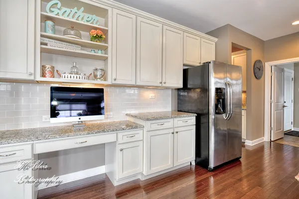 a kitchen with stainless steel appliances granite countertop a refrigerator and a stove top oven
