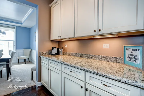 a kitchen with granite countertop white cabinets and a sink