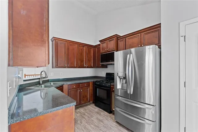 a kitchen with stainless steel appliances granite countertop a refrigerator sink and stove