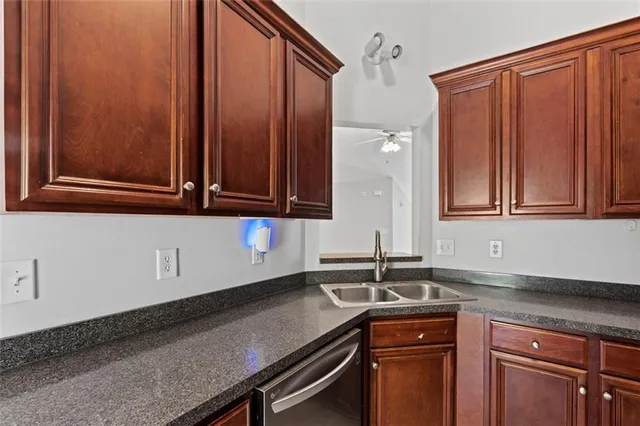 a kitchen with granite countertop stainless steel appliances a sink and cabinets