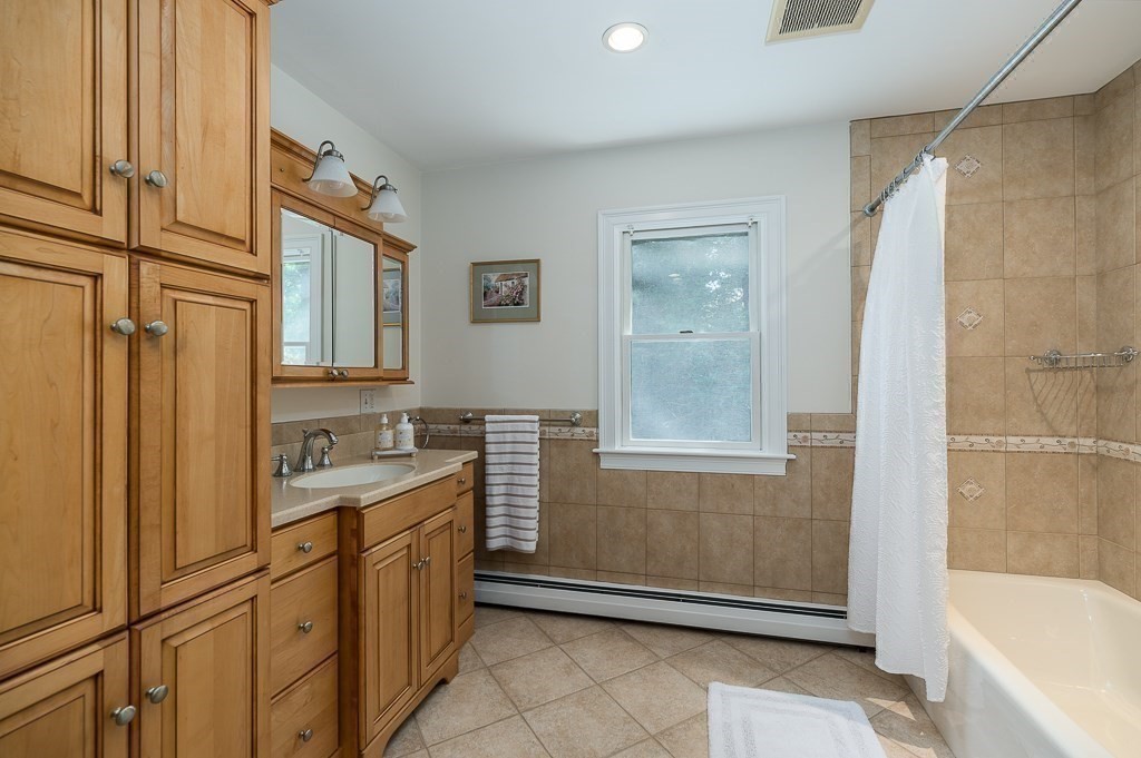 20 R Edgemoor Road Gloucester, MA 01930 - Photo 26 of 33 a bathroom with a granite countertop sink a mirror and a bathtub