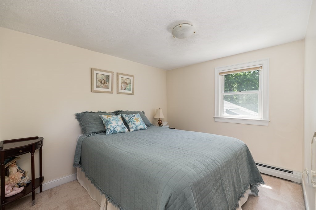 20 R Edgemoor Road Gloucester, MA 01930 - Photo 30 of 33 a large bed sitting in a bedroom next to a window